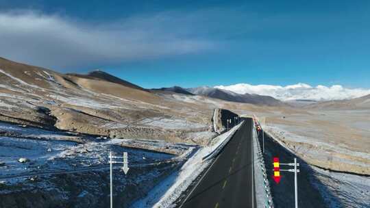 航拍冬季蓝天白云雪山之间的219国道视频