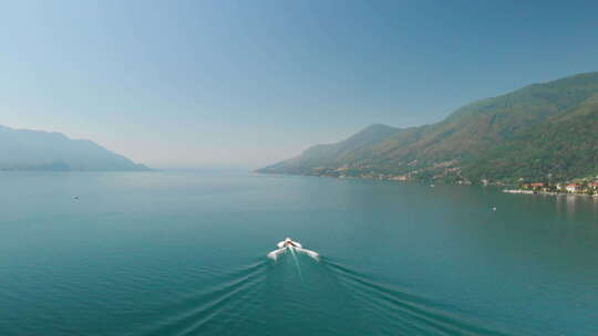 意大利马焦雷湖上一艘船巡航的广角镜头。多莉向后，露出镜头