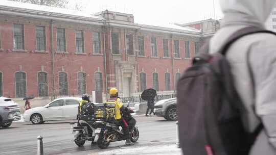 遵守交通规则雪中等红灯的美团外卖小哥街头