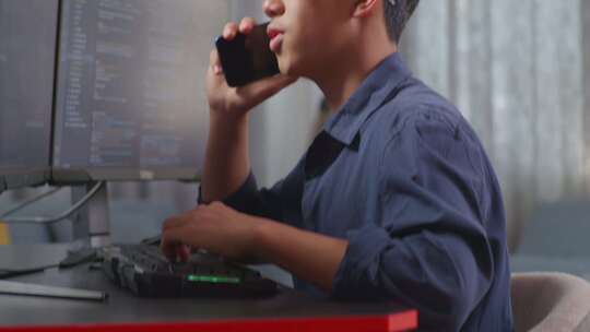 亚洲男孩程序员在创建软件工程师开发应用程序、程序时在智能手机上说话