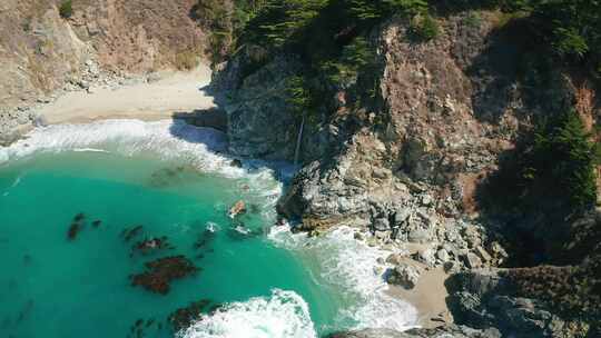 瀑布涌入海滩和山丘附近的大海