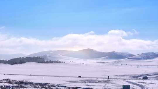 辽阔雪地上阳光照耀下的山峦