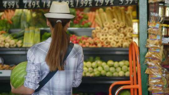 女人在商店的农产品区看芹菜