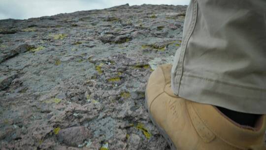 穿黄色靴子的男子在石头上行走