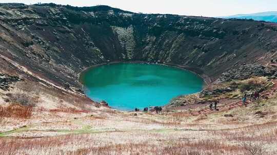 游客参观冰岛凯里德火山口湖的高角度视图