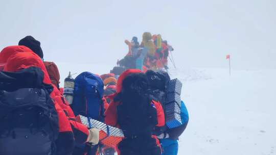 风雪天气中攀登慕士塔格峰雪山的登山队