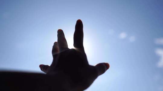 手握阳光穿过指缝手握住拳头伸手遮住太阳光