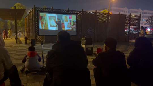 夜晚广场看幕布电影的居民3视频素材模板下载