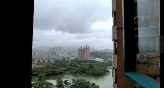 窗外看出去窗外下着雨，黑云密布下雨的湖面视频素材模板下载