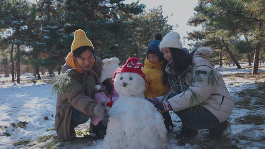 快乐家庭在雪地里堆雪人