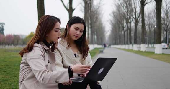 美女大学生在校园使用笔记本电脑