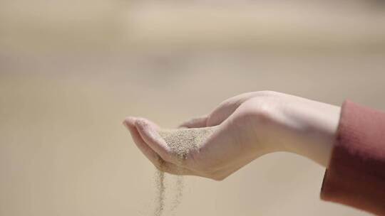 黄色细沙从女人的手掌流下
