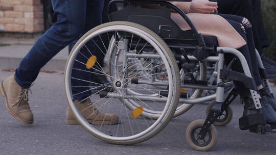 女人和男人推着残疾人朋友在散步视频素材模板下载