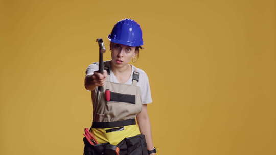 女性建筑工人用锤子危险行事