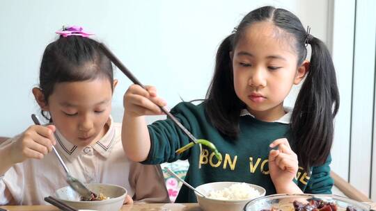 大口吃饭的两名中国女孩