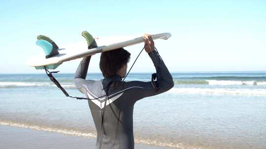 男人把冲浪板举过头顶