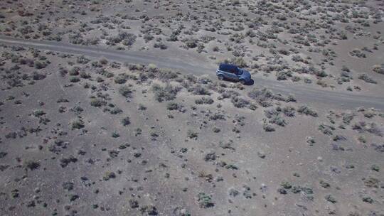 航拍在沙漠道路上行驶的汽车