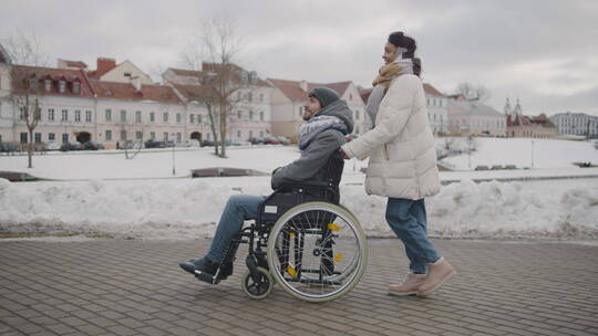 推着轮椅上的男人散步的女人视频素材模板下载