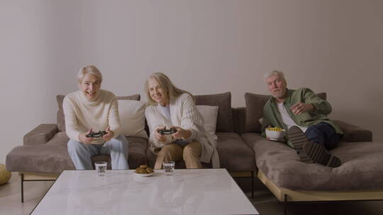 沙发上玩电子游戏的快乐老人