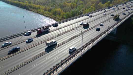 市区跨河公路桥高速公路鸟瞰图。卡车在桥上行驶。Sk