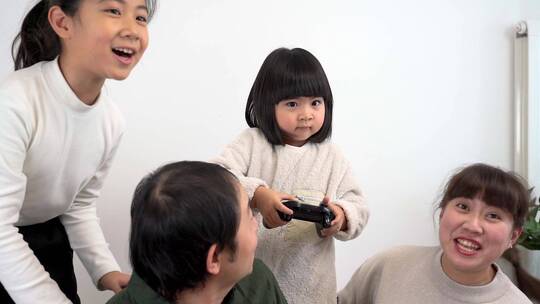 坐在客厅沙发上玩电子游戏的四口之家视频素材模板下载