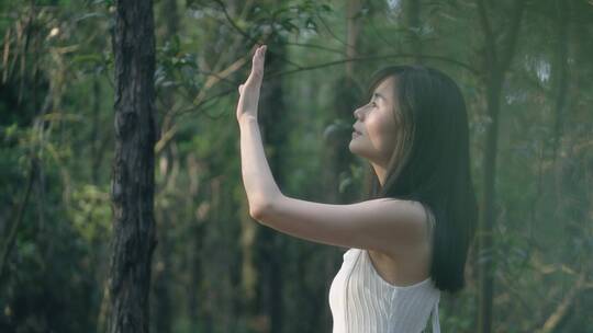 清新唯美女孩在树林里伸手遮挡太阳4k素材