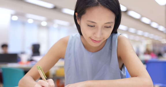 年轻女子在大学图书馆学习