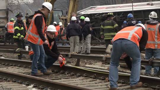 救援人员在脱轨的列车旁展开救援