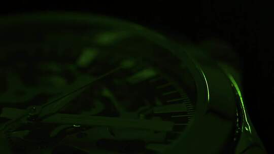 绿光照射中的手表指针转动