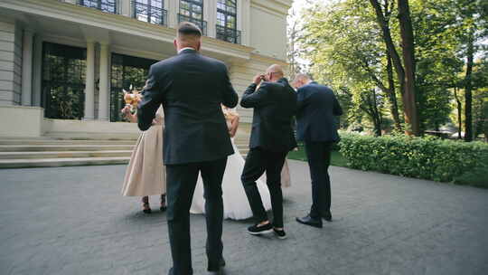 婚礼派对在会场外庆祝新娘和新郎在台阶上与