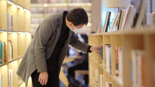 年轻男子在现代图书馆看书学习