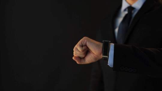 穿着西装的商务男士抬手操作戴着的智能手表视频素材模板下载