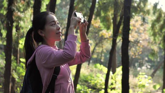 亚洲中国人女人树林旅游漫步拍照对话看风景