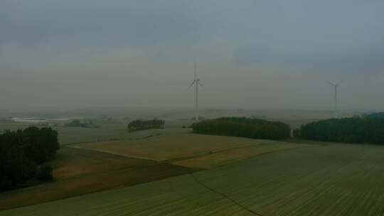 风力发电场雾蒙蒙的早晨，风车在田野里靠得很近，