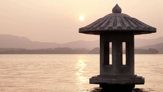 夕阳下波光粼粼的西湖和灯塔