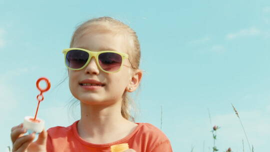 女孩戴着太阳镜吹泡泡视频素材模板下载