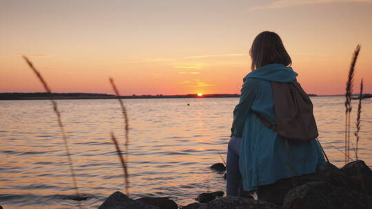 女人坐在海边欣赏日落视频素材模板下载
