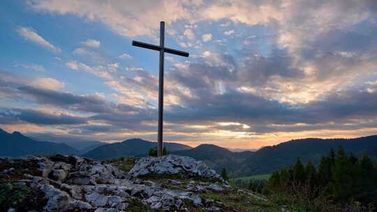 日落时分岩石上的基督教十字架