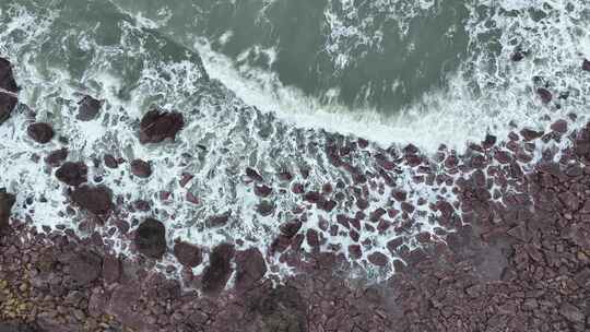 海岸礁石沙滩海水拍打礁石阴天海滩海浪冲刷视频素材模板下载