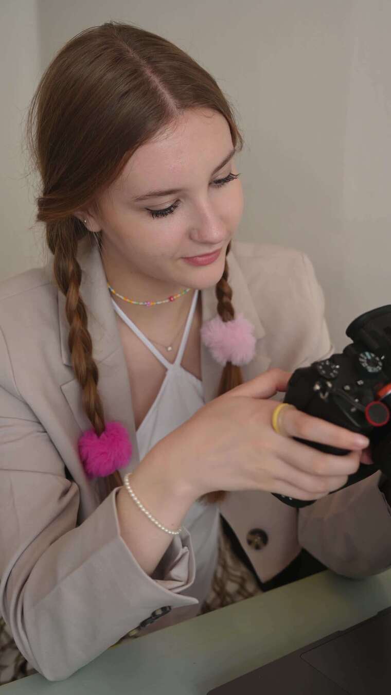 一名年轻女子在看数码单反相机上的照片