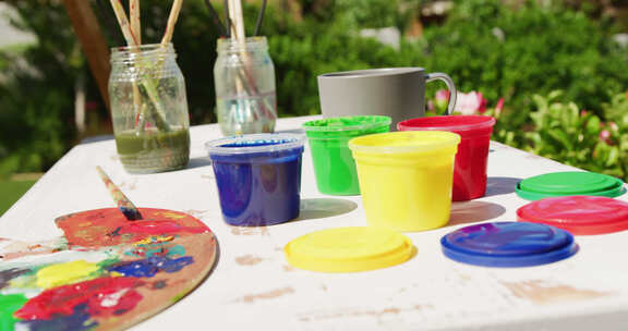 花园里桌子上彩色油漆和绘画设备的特写
