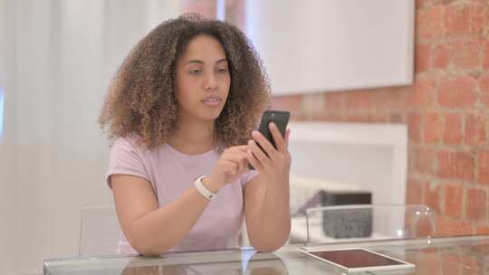 非裔美国女性在智能手机上庆祝成功
