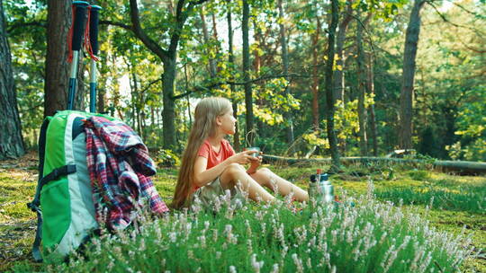 坐在草地上喝茶的女孩