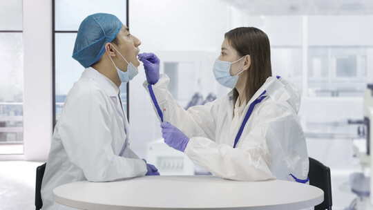 身穿防护服的医疗研究人员在做核酸检测