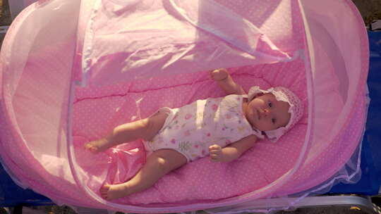 海滩上穿着粉色低音管的婴儿
