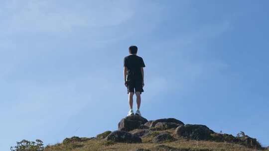 男子立于山顶眺望远方