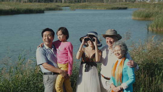 一家五口在湖边草丛中观鸟