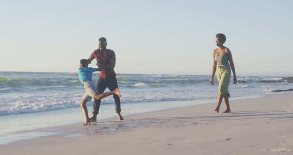 日落时快乐的非裔美国家庭在海滩上玩得开心的视频