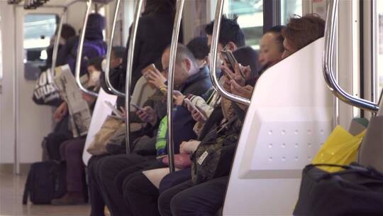 通勤者在火车上使用智能手机