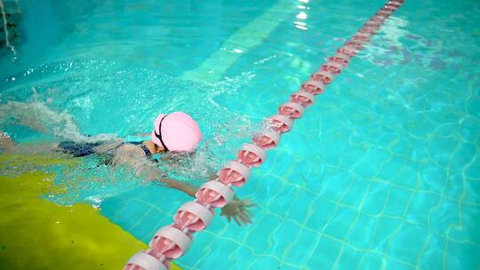 在泳池练习游泳的中国女孩